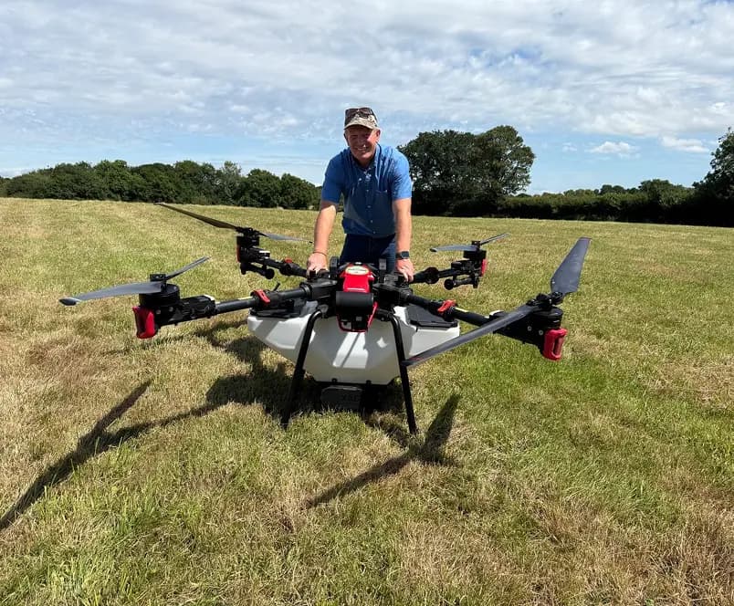 Ben Hargreaves with a large agricultural spraying drone in a field